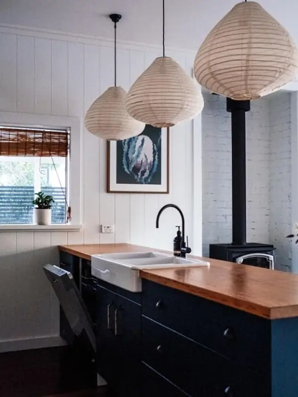 Modular kitchen with timber counter, farmhouse sink and paper pendant lights