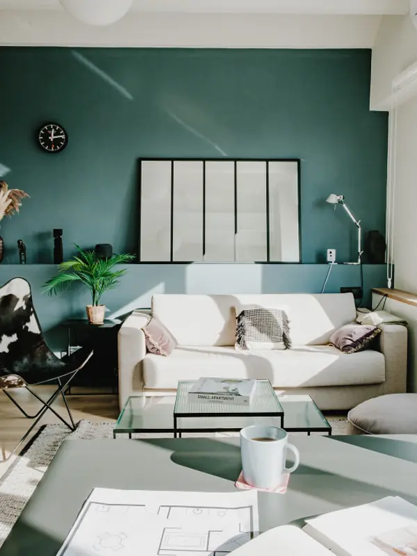 Living room with green panelled walls and herringbone flooring